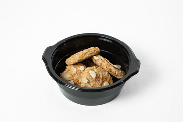 Sugar-free cookies with almonds and walnuts on a plate on a white background