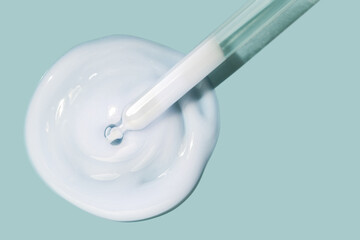 Pipette translucent serum texture white swatch sample on light navy blue background. Cosmetic beauty skin care product moisturizer