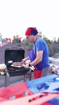 Chilean Independence Day vertical video: Man placing anticuchos on grill wearing Chilean flag apron with festive background