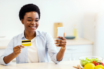 Grocery Shopping Application For Phone. African Woman Holding Credit Card Using Smartphone Buying...