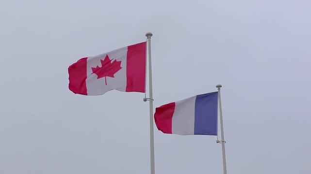 Flags of Canada and France in the wind Normandy June Beach.