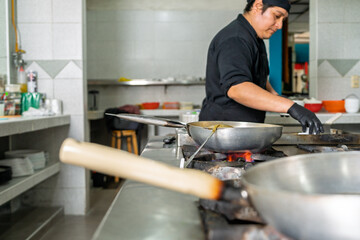 Latin chef cooking seafood in restaurant kitchen