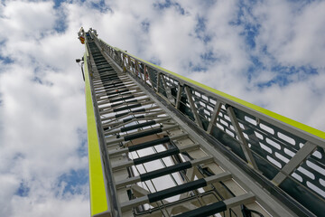 Rescue ladder of Flensburg fire department rises towards the sky under light clouds and blue skies