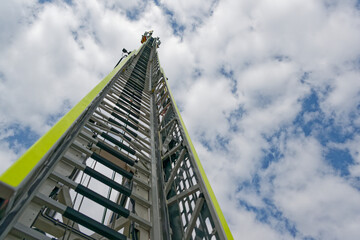 Rescue ladder of Flensburg fire department rises to the sky under light clouds and blue skies © Holger