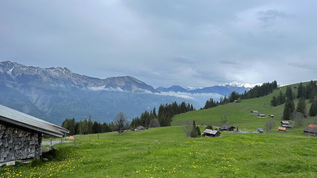 Swiss landscapes feature rolling green hills, snowy mountains, cozy wooden cabins under Switzerland landscape