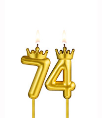Golden number 74 birthday candle on white background