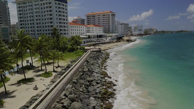 Drone flies up and away from beachside viewpoint in La Ventana al Mar park, along Condado Beach in the morning in San Juan, Puerto Rico