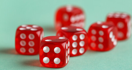 Red dices on turquoise background, closeup