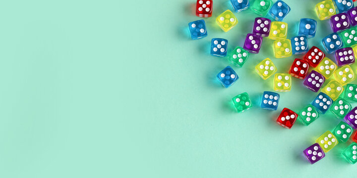 Many colorful dices on turquoise background with space for text