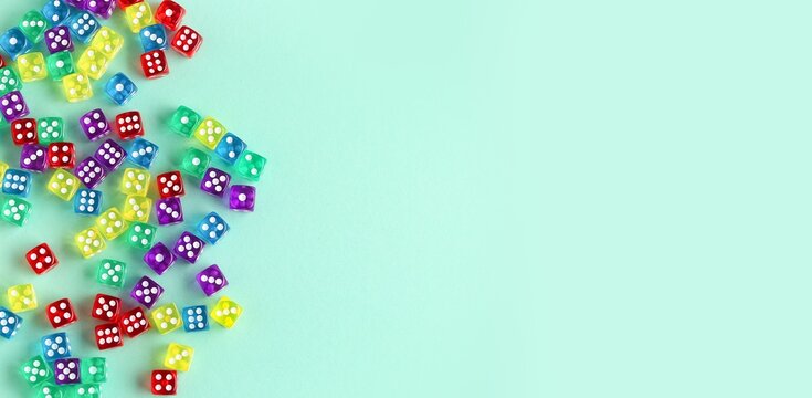 Many colorful dices on turquoise background with space for text
