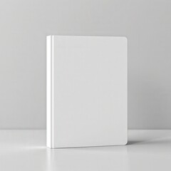 Naklejka premium Blank white notebook standing on clean surface, simple and modern design for creative projects and photography