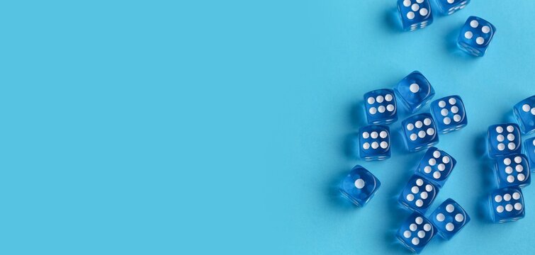 Many dices on blue background with space for text, top view