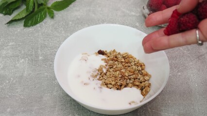 bowl with Greek yogurt homemade granola, mixed nuts, almond, cashew, hazelnut. Healthy vegetarian protein diet breakfast. Selective focus, closeup