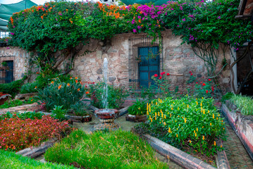 Colonial courtyard in La Antigua Guatemala, framed by lush plants and towering trees. A peaceful...