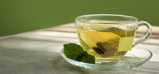 Cup of hot tea with mint on table, closeup