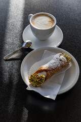 Italy. Bari. Breakfast with cappuccino and cannoli.