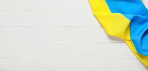 Flag of Ukraine on white wooden background with space for text