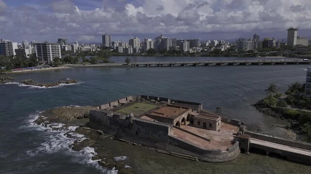 Drone orbits seaside fort in medium-close up shot on sunny morning in San Juan, Puerto Rico