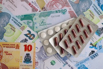Nigerian naira currency money bills and medicine pills. The concept of medicine and pharmacy