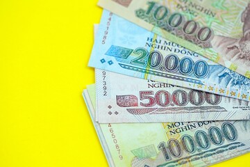 Vietnamese dong money bills in big amount on yellow. Finance and banking concept