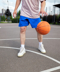 Fototapeta premium Bouncing basketball on a sunny day at the urban court