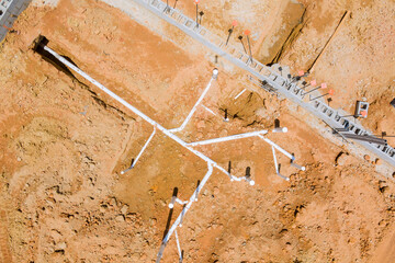 Complex network of PVC pipes laid out on foundation area construction site preparation for future building projects.