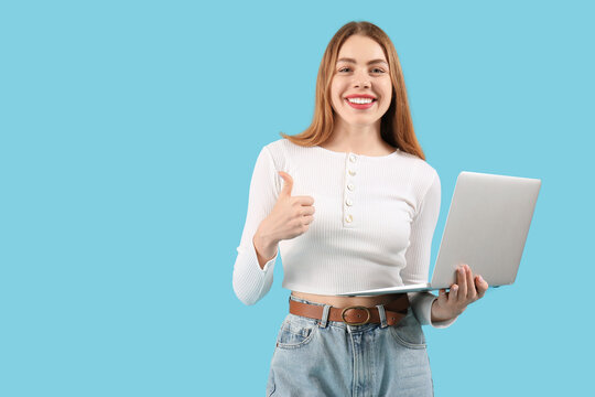 Female programmer with laptop showing thumb-up on blue background