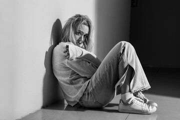 Depressed young woman sitting in hall