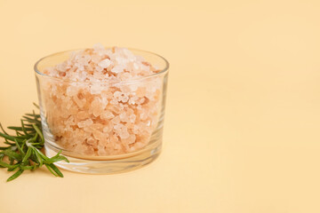 Glass bowl with Himalayan pink salt and rosemary on orange background