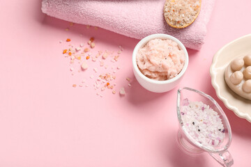 Bowl of body scrub, sea salt and clean towel on pink background