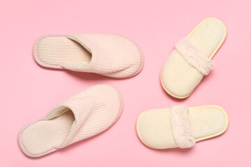 Two pairs of slippers on pink background. Top view