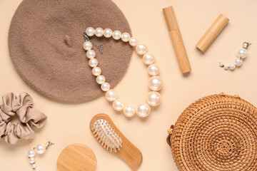 Cap, pearl necklace and wicker bag on beige background