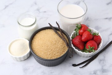 Different ingredients for panna cotta. Milk, sugar, vanilla and strawberries on white marble table, closeup