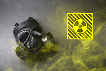 Radiation threat. Gas mask, radioactive sign and smoke on grey background, top view