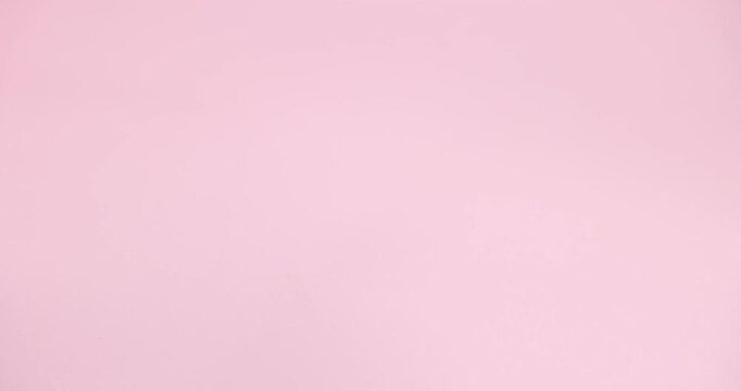 Woman taking light blue visor cap on pink background, closeup
