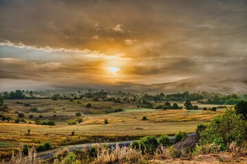 Fototapeta premium Sunrise over a serene rural landscape.