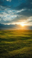 Sunrise over a vast grassy plain, mountains in the distance