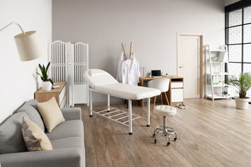 Interior of medical office with couch, sofa and doctor's workplace