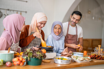 Muslim family cooking together in kitchen preparing food with fresh vegetables, islamic holiday gathering with fresh ingredients and family love, halal food preparation for ramadan or eid celebration