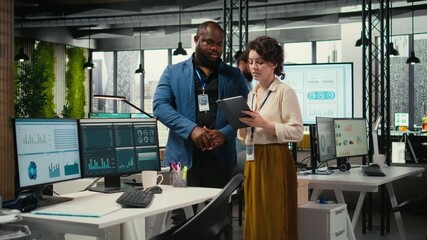 Diverse workers team use digital tools and analytics to improve growth strategy, reviewing financial insights on tablet to foster innovation and development in a modern office environment. Camera A. - Powered by Adobe