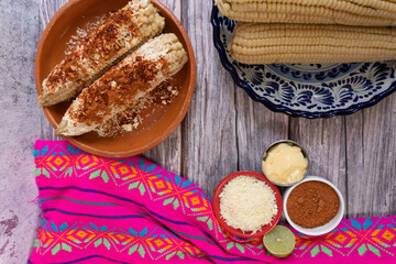 Top view of a table with several prepared and unprepared corn cobs, Mexican food