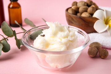 Bowl with shea butter on pink background, closeup