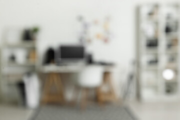 Blurred view of office with photographer's workplace and shelf units