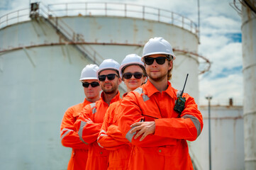 Photo group of professional males and females refinery engineers team standing arm cross in oil refinery petrochemical tank