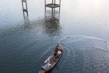Obraz premium Fisherman of Bangpra Lake in action when fishing, Thailand.