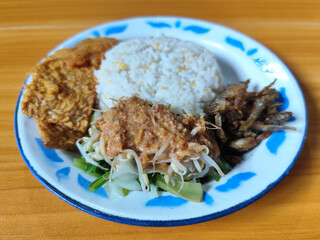 Nasi pecel or sego pecel is a typical Javanese Indonesian dish served with pecel sauce, which can be added with vegetables, peyek, fish, crackers, tempeh and other side dishes.