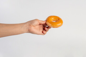 Glazed donut in hand on white background