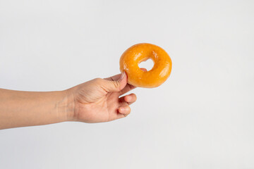 Glazed donut in hand on white background