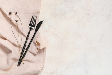 Napkin with cutlery and branch on beige grunge background