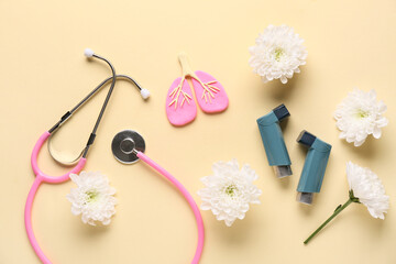 Asthma inhalers with stethoscope, lungs figurine and chrysanthemum flowers on beige background